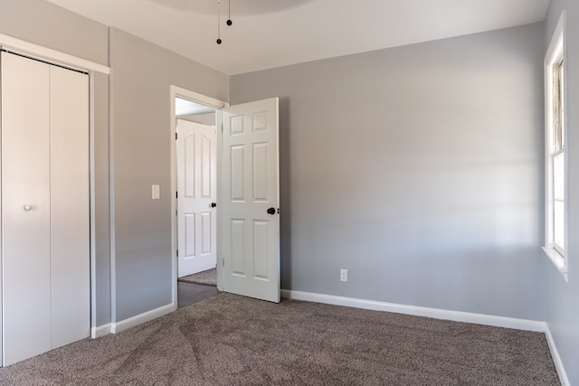 unfurnished bedroom featuring carpet and baseboards