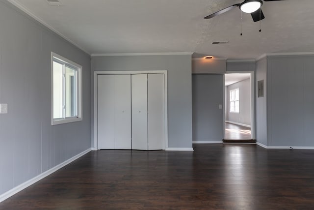 unfurnished bedroom featuring dark wood-style floors, visible vents, and crown molding