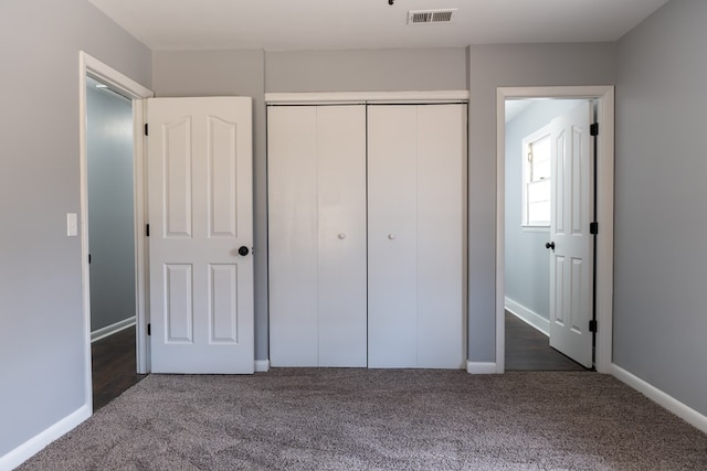 unfurnished bedroom with baseboards, a closet, visible vents, and carpet flooring