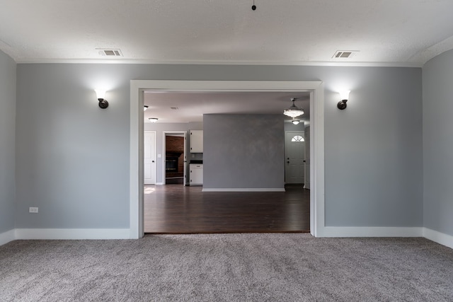 carpeted empty room featuring a textured ceiling, visible vents, and baseboards