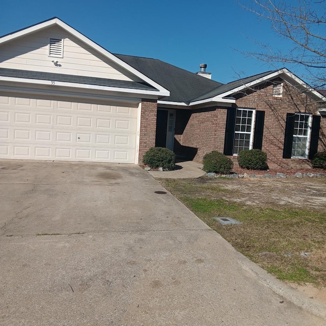 single story home featuring an attached garage, concrete driveway, and brick siding