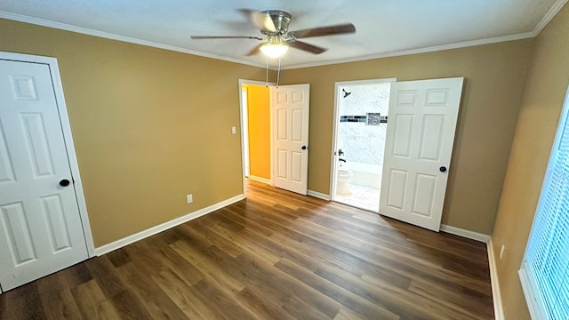 unfurnished bedroom featuring crown molding, connected bathroom, dark wood finished floors, and baseboards