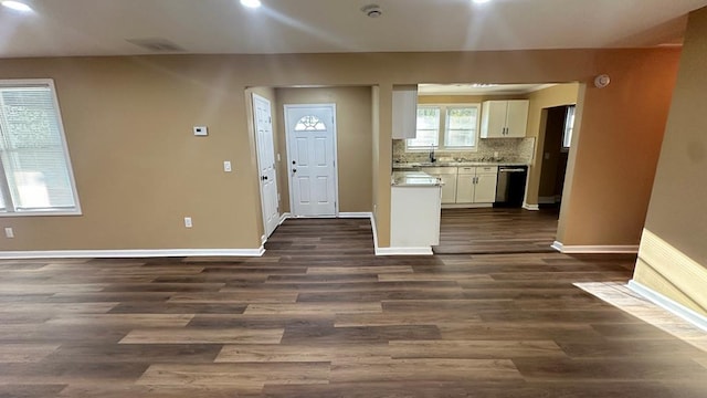 kitchen with dark wood finished floors, light countertops, decorative backsplash, white cabinets, and baseboards