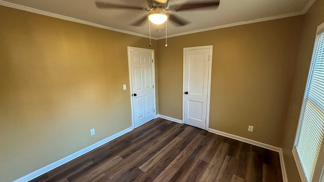 empty room with dark wood-style floors, ornamental molding, a ceiling fan, and baseboards