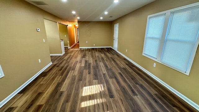 unfurnished room featuring recessed lighting, dark wood-style flooring, visible vents, and baseboards