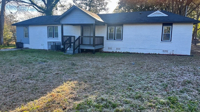 view of front of home with crawl space, brick siding, a front lawn, and central air condition unit