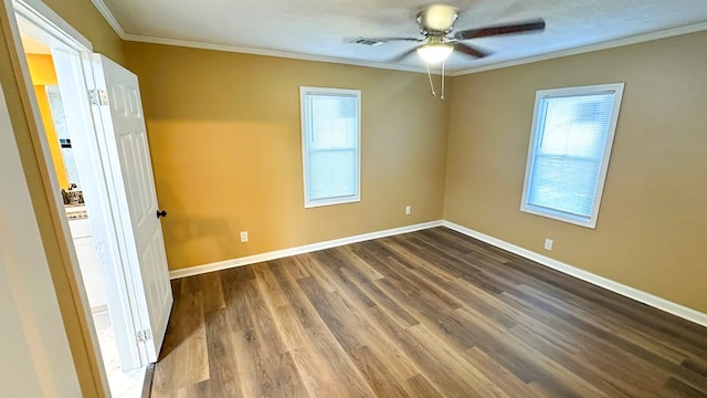 unfurnished room with ornamental molding, a healthy amount of sunlight, baseboards, and dark wood-style floors