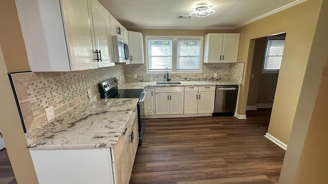 kitchen featuring stainless steel appliances, a sink, visible vents, and white cabinets