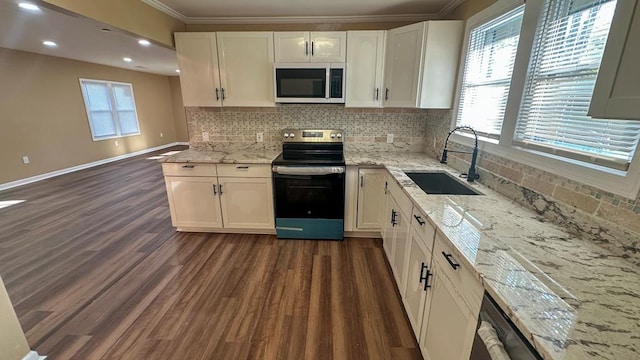 kitchen with stainless steel appliances, white cabinets, a sink, and dark wood-style floors