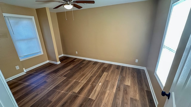 empty room featuring dark wood-style floors, baseboards, and a ceiling fan