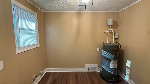 laundry area featuring a textured ceiling, dark wood-style flooring, visible vents, baseboards, and water heater