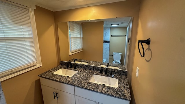 bathroom featuring double vanity, walk in shower, and a sink