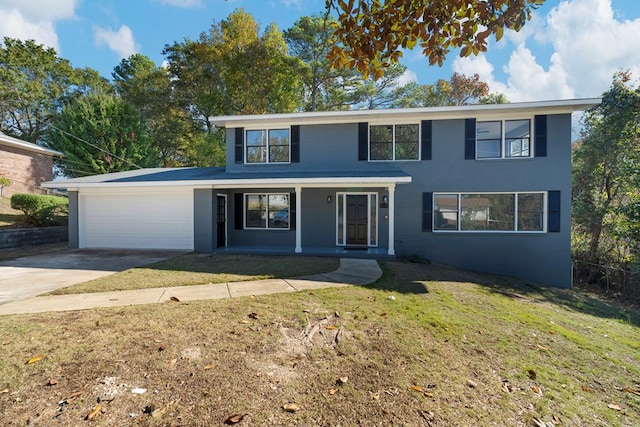 view of front property featuring a porch, a garage, and a front yard