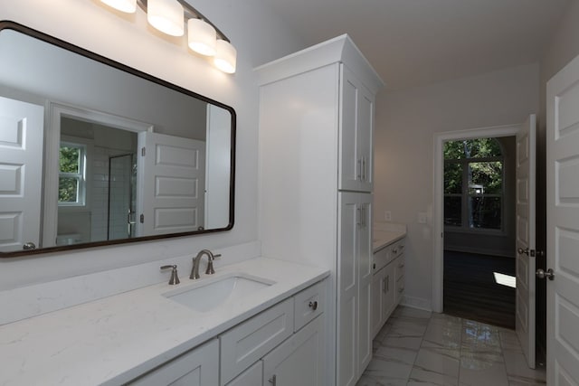 bathroom featuring vanity, walk in shower, and a healthy amount of sunlight