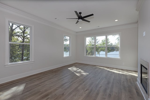 unfurnished living room featuring ceiling fan, a water view, ornamental molding, and dark wood-type flooring