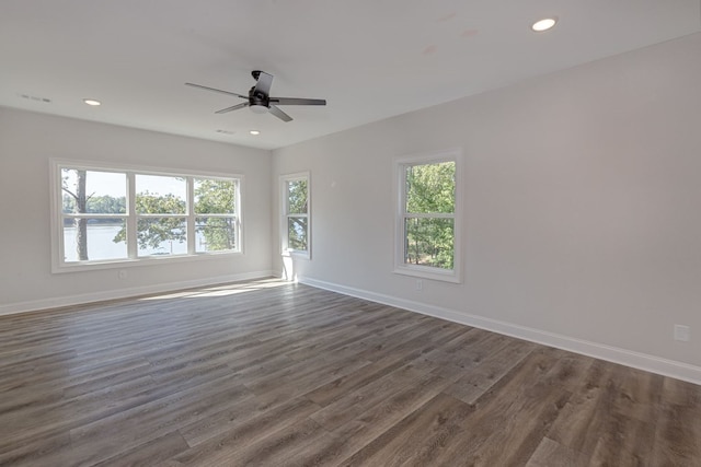 empty room featuring dark hardwood / wood-style flooring, plenty of natural light, and ceiling fan