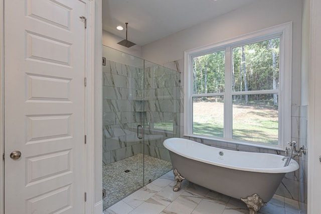 bathroom with shower with separate bathtub, a wealth of natural light, and tile walls