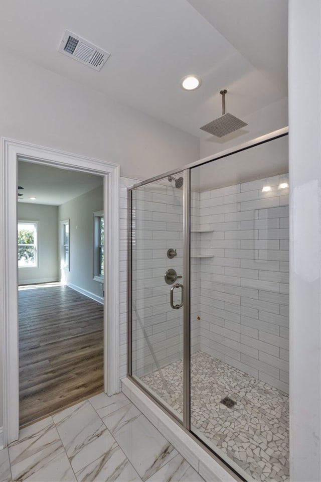 bathroom featuring hardwood / wood-style flooring and a shower with shower door