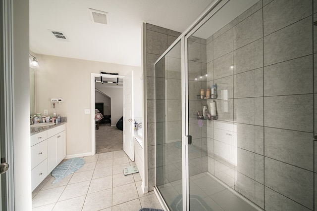 bathroom featuring tile patterned floors, vanity, and a shower with shower door