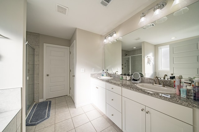 bathroom with tile patterned floors, vanity, and an enclosed shower