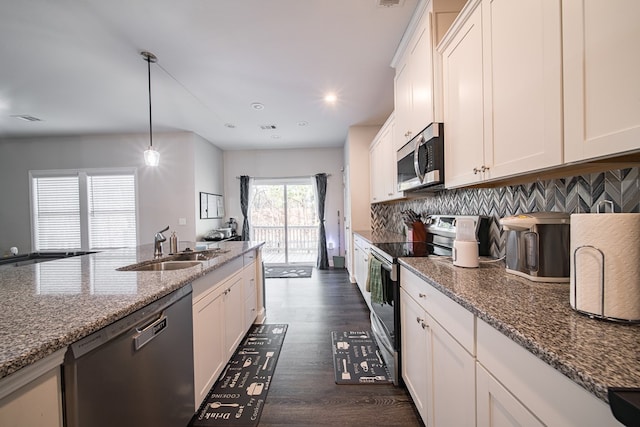 kitchen with white cabinetry, light stone countertops, dark hardwood / wood-style flooring, pendant lighting, and appliances with stainless steel finishes