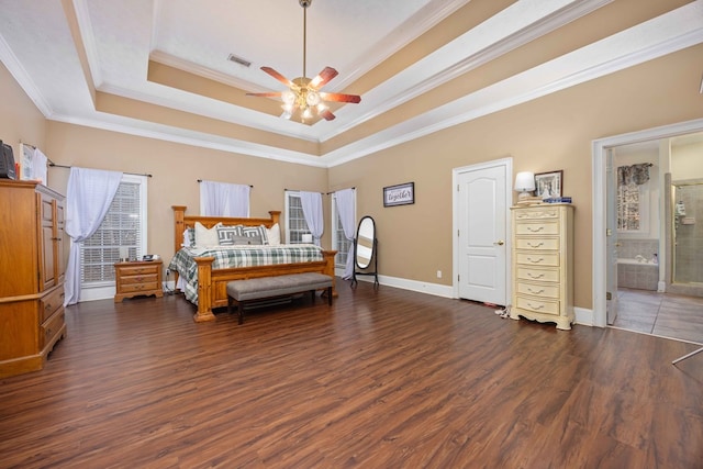 bedroom with ceiling fan, dark hardwood / wood-style floors, connected bathroom, ornamental molding, and a raised ceiling