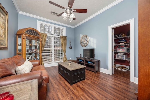 living room featuring ceiling fan, crown molding, dark hardwood / wood-style floors, and a textured ceiling