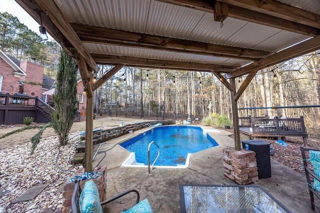 view of swimming pool featuring a patio and a wooden deck