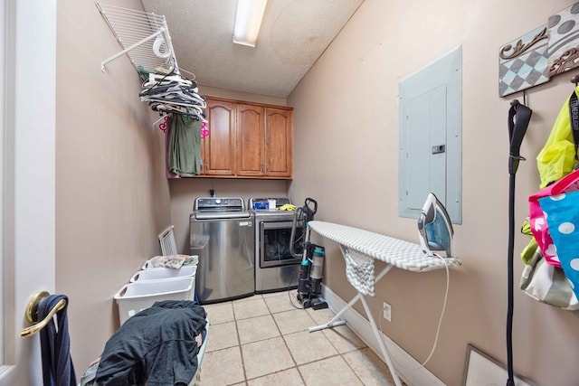 laundry room with light tile patterned flooring, cabinets, electric panel, washing machine and dryer, and a textured ceiling