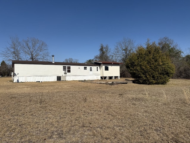 back of property with central AC and a yard