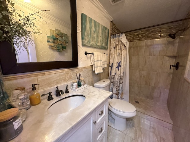 full bathroom featuring ornamental molding, a tile shower, vanity, and toilet