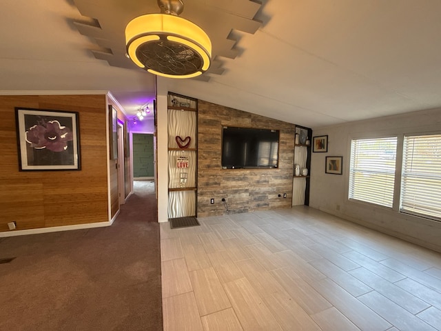 unfurnished living room featuring lofted ceiling and wooden walls