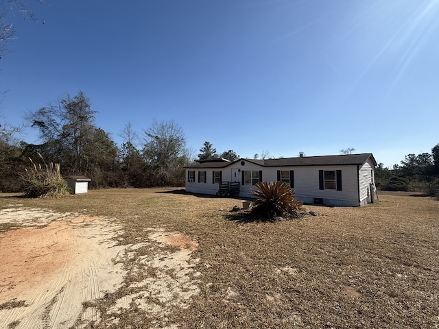 view of front facade with crawl space, an outdoor structure, and a shed