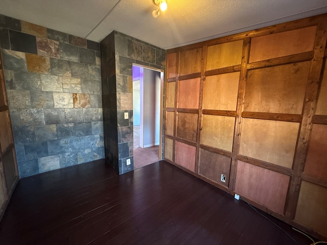 spare room with dark wood finished floors and a textured ceiling