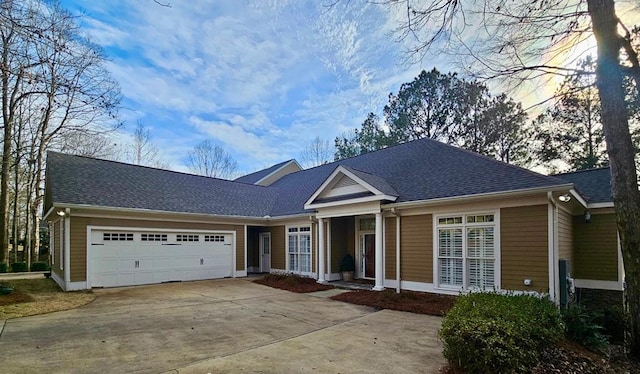 ranch-style house with a garage, a shingled roof, and concrete driveway