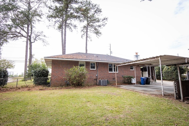 rear view of property with a yard, central AC unit, and a patio area