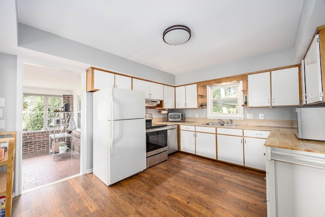 kitchen with white cabinets, dark hardwood / wood-style flooring, sink, and appliances with stainless steel finishes