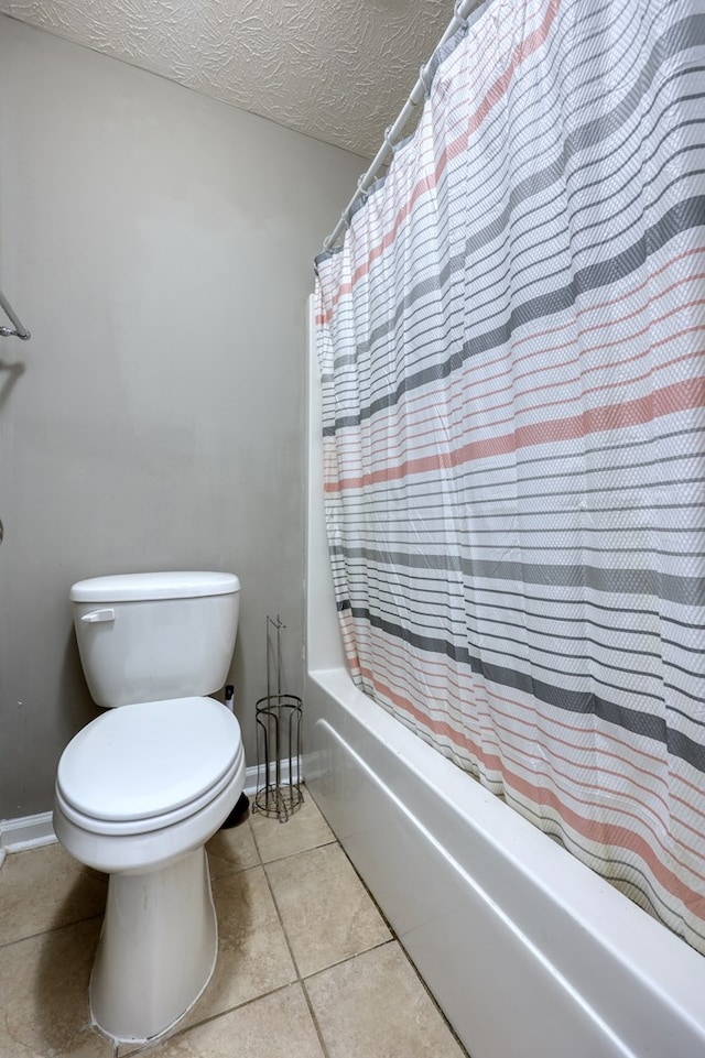 full bathroom featuring tile patterned floors, toilet, a textured ceiling, shower / tub combo, and baseboards