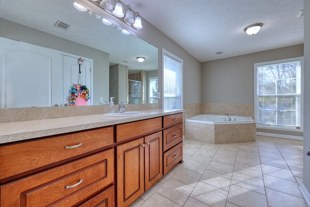 full bathroom with vanity, a bath, visible vents, and a wealth of natural light