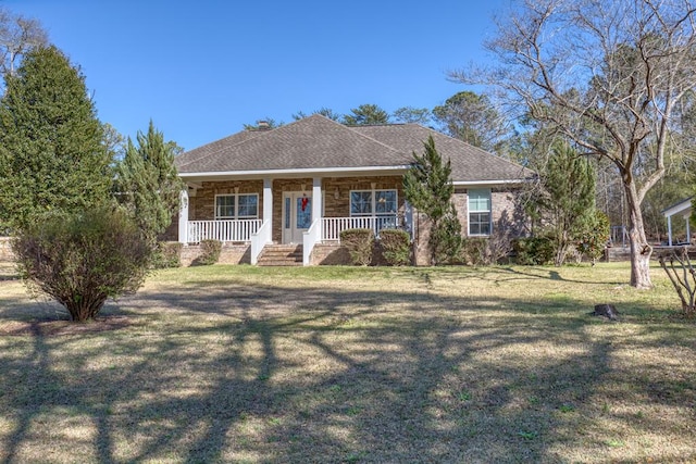 view of front of house with roof with shingles, a porch, and a front yard