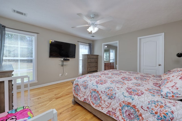 bedroom featuring light wood-type flooring, baseboards, visible vents, and ceiling fan