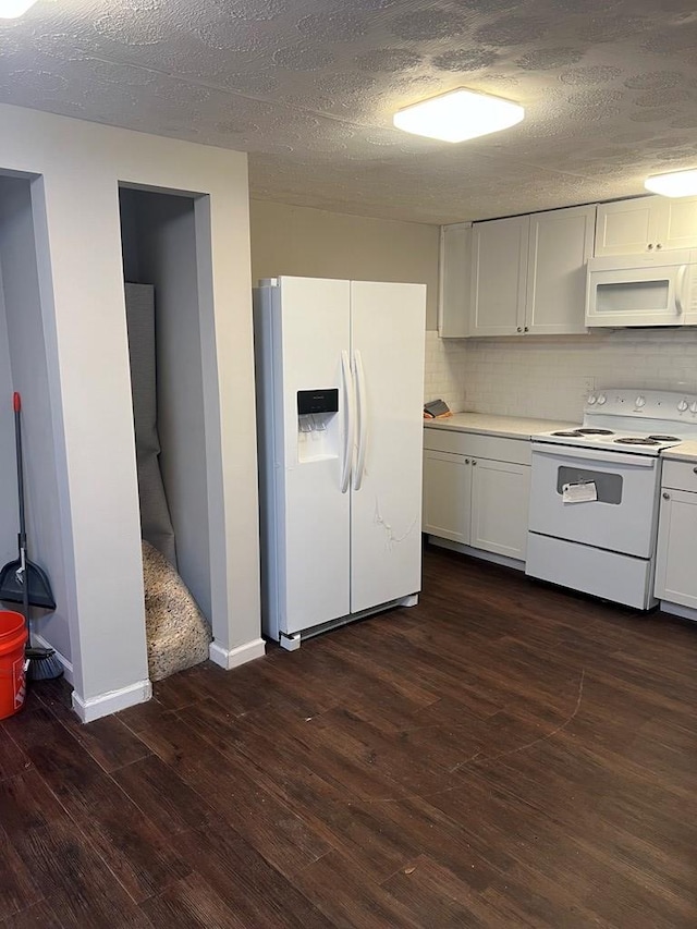 kitchen with white cabinets, dark hardwood / wood-style flooring, white appliances, and a textured ceiling