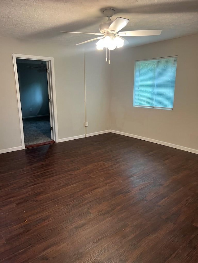 spare room with ceiling fan, dark wood-type flooring, and a textured ceiling