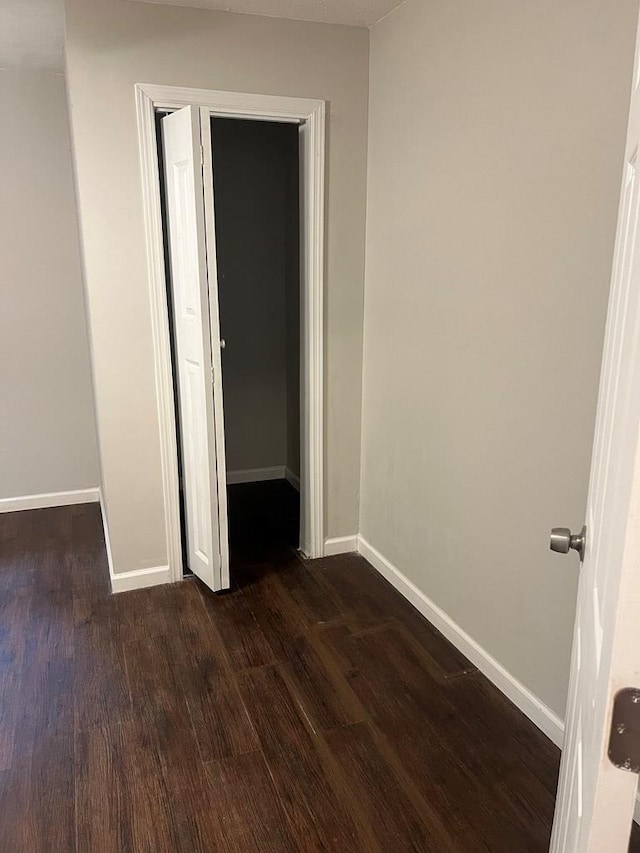 unfurnished bedroom featuring a closet and dark wood-type flooring