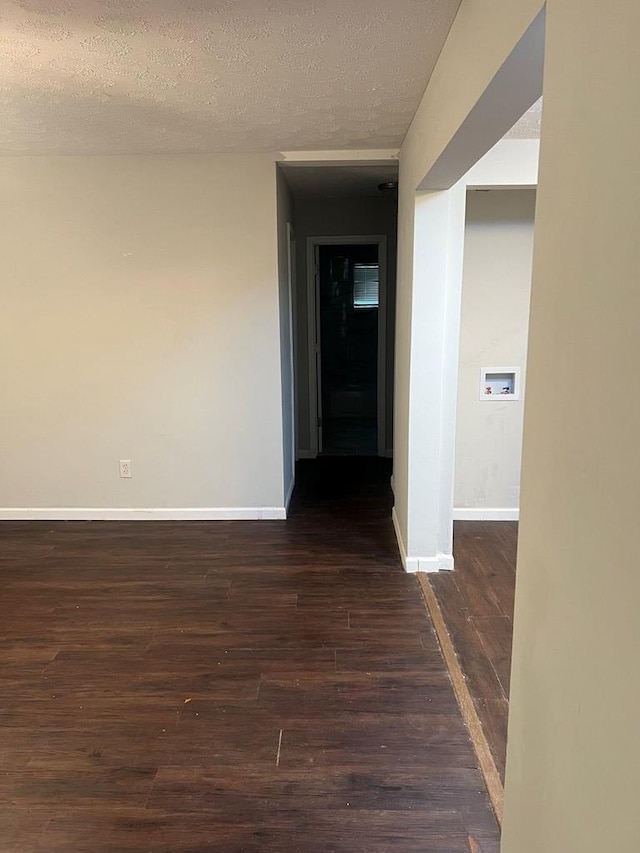 hallway with dark hardwood / wood-style flooring and a textured ceiling