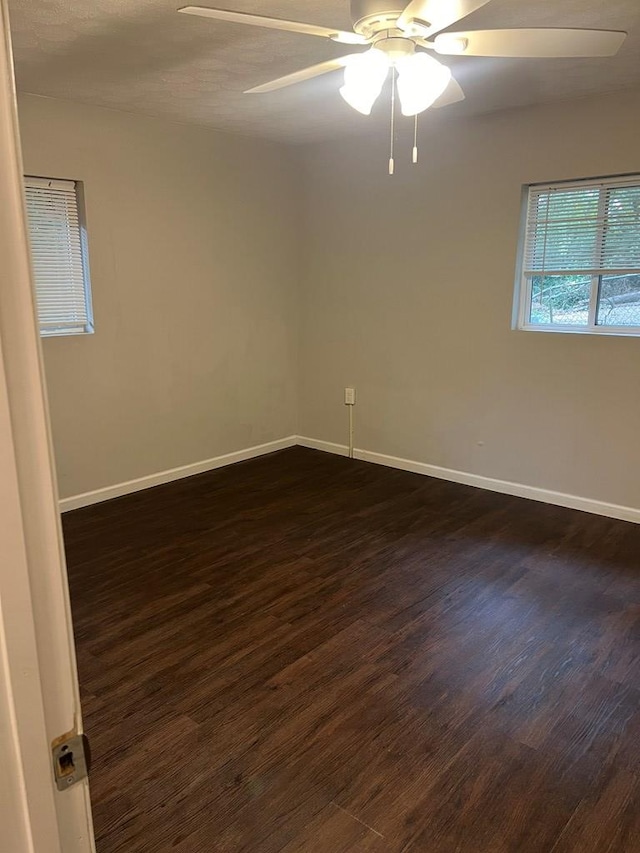 empty room with dark hardwood / wood-style floors and ceiling fan