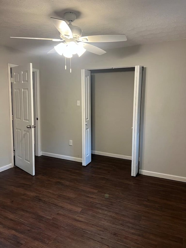 unfurnished bedroom featuring ceiling fan, dark hardwood / wood-style flooring, and a textured ceiling