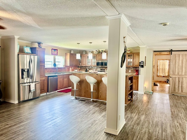 283 Roberts Rd, Hahira, GA 31632 - kitchen with stainless steel appliances, crown molding, dark wood finished floors, a textured ceiling, and a kitchen breakfast bar
