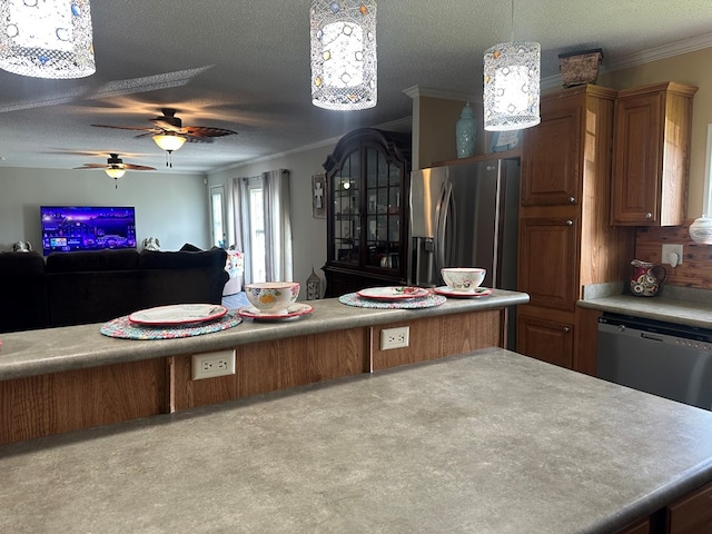 283 Roberts Rd, Hahira, GA 31632 - kitchen with stainless steel appliances, open floor plan, crown molding, a ceiling fan, and brown cabinets
