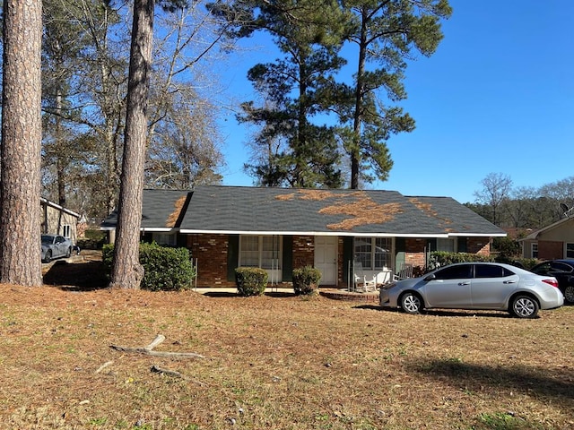 ranch-style house featuring a porch and a front yard